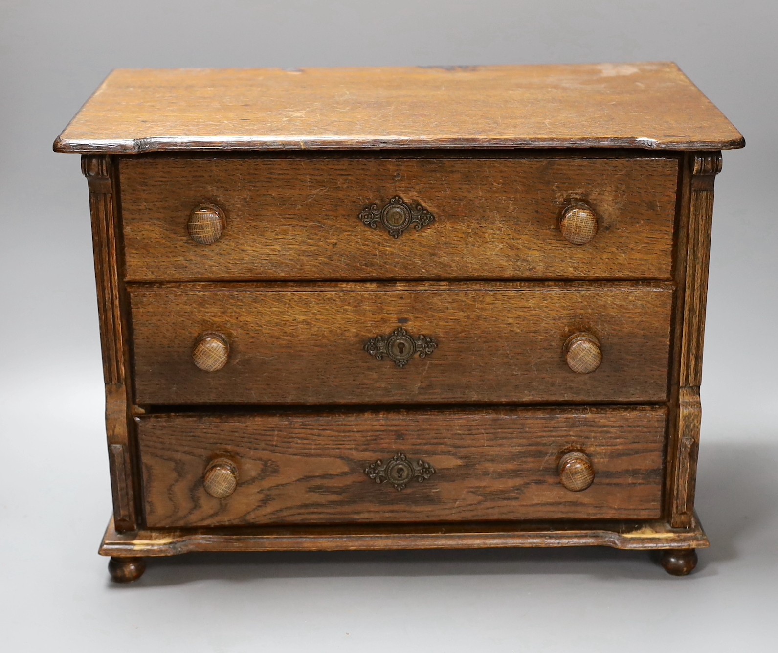 An oak table top chest of three drawers, 39.5cm wide